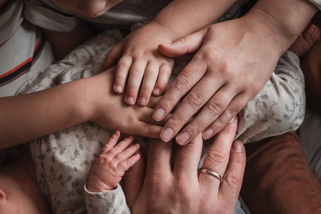 Handen van gezinsleden tijdens newbornshoot door Sabrina Wennekes fotografie Nijmegen